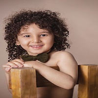 صورة لصبی ذو شعر مجعد،ربطة عنق خضراء
